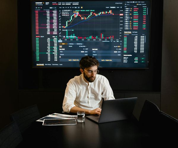 Professional analyst reviewing comprehensive economic data on multiple screens
